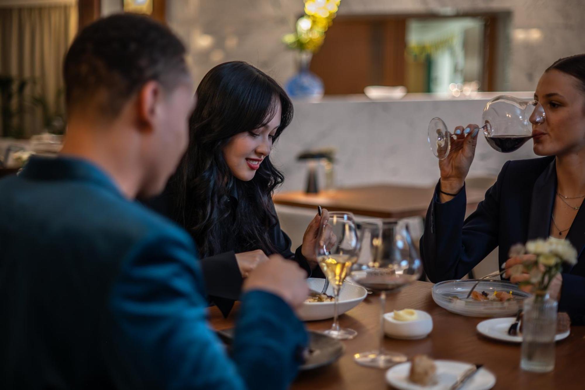 Almanac X Alcron Prague Hotel Exterior photo A woman using a mobile phone while dining